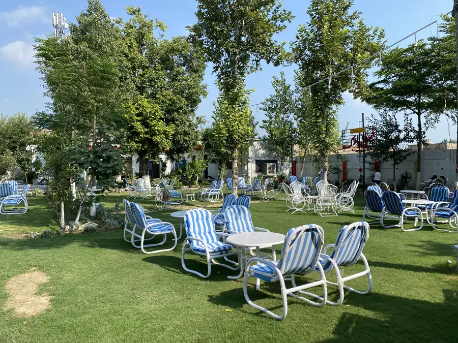 Shaded garden chairs and tables at Safdar Hotel Family Park